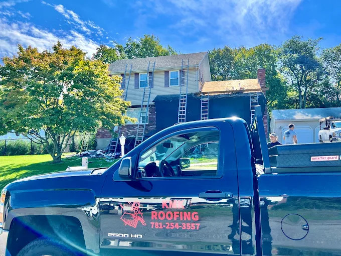 KMK Roofing truck parked in front of a house during a roof tear-off
